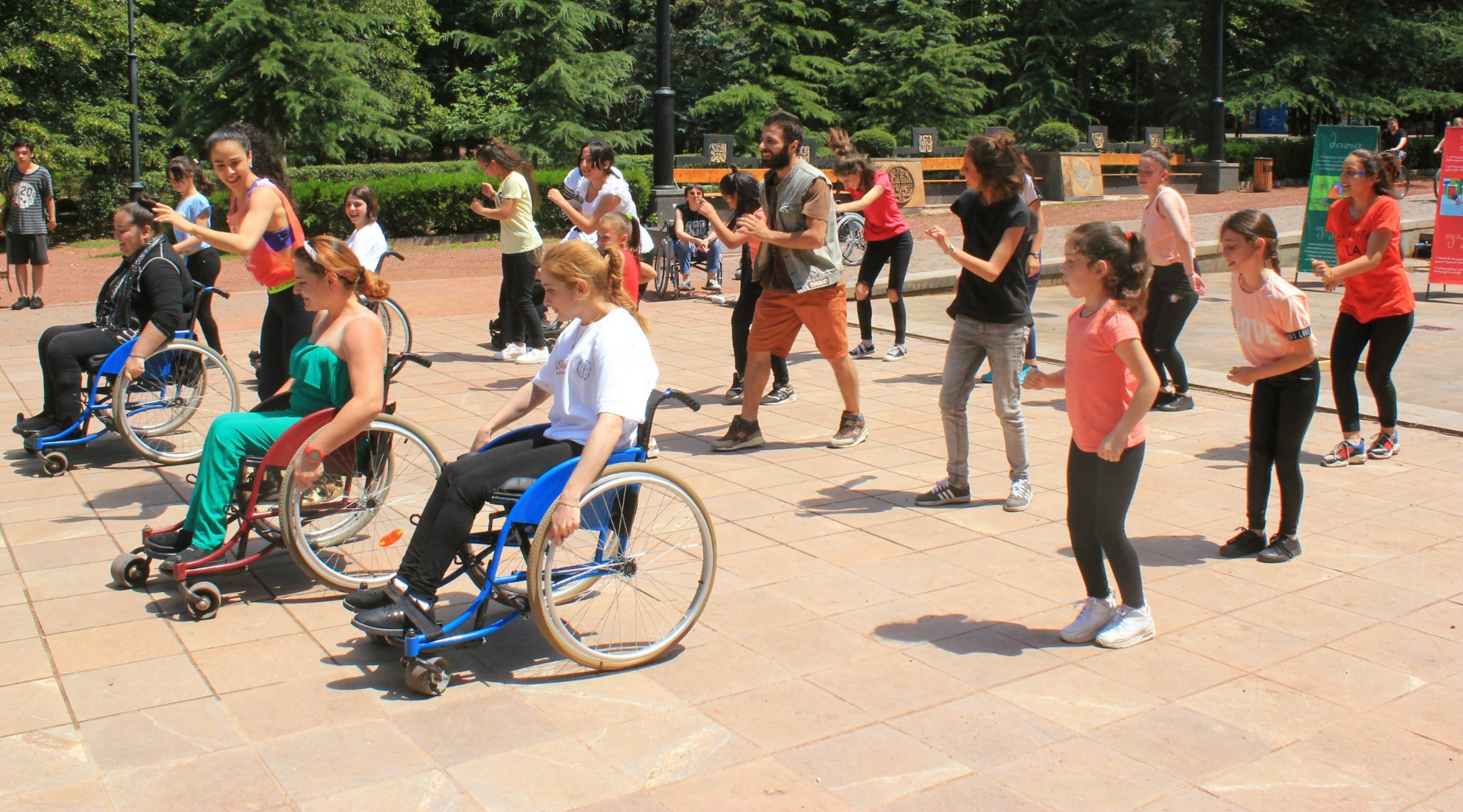 A large group of people dancing, with wheelchair users in the front