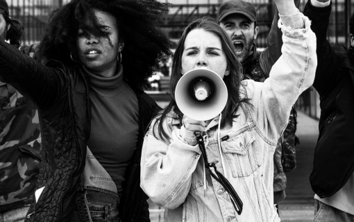 Mixed gender, multi racial group standing in protest.