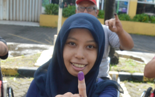 People showing their ink stained hands after voting.