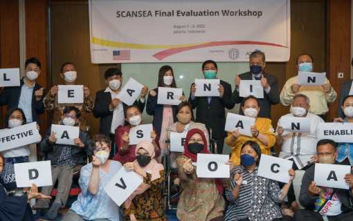 AGENDA Evaluation Event, participants hold letters in front of sign.