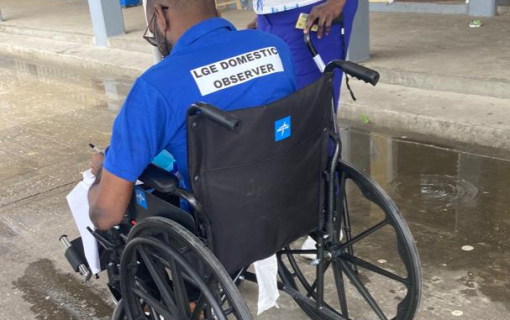 Election observer using a wheelchair chatting with a colleague