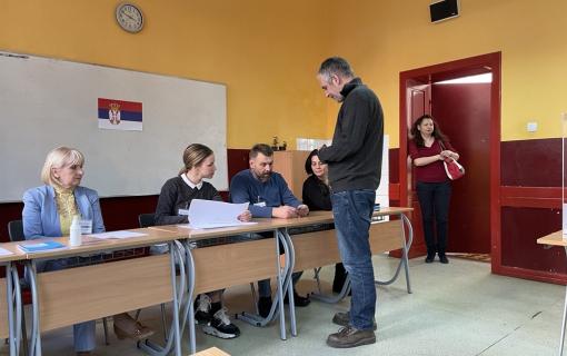 Man presenting his voter identification to Polling Board members before receiving his ballot.