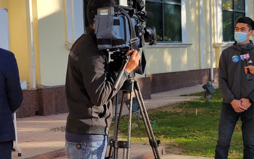 person operating camera  with reporter in Uzbekistan.