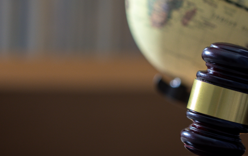 a gavel placed in front of a globe in a study.