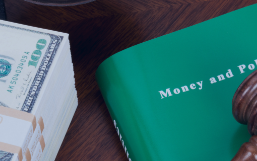 Book money and politics with gavel on top next to a stack of money on a desk. photo credit ericsphotography via canva pro