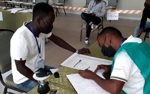 Man signing a ballot.