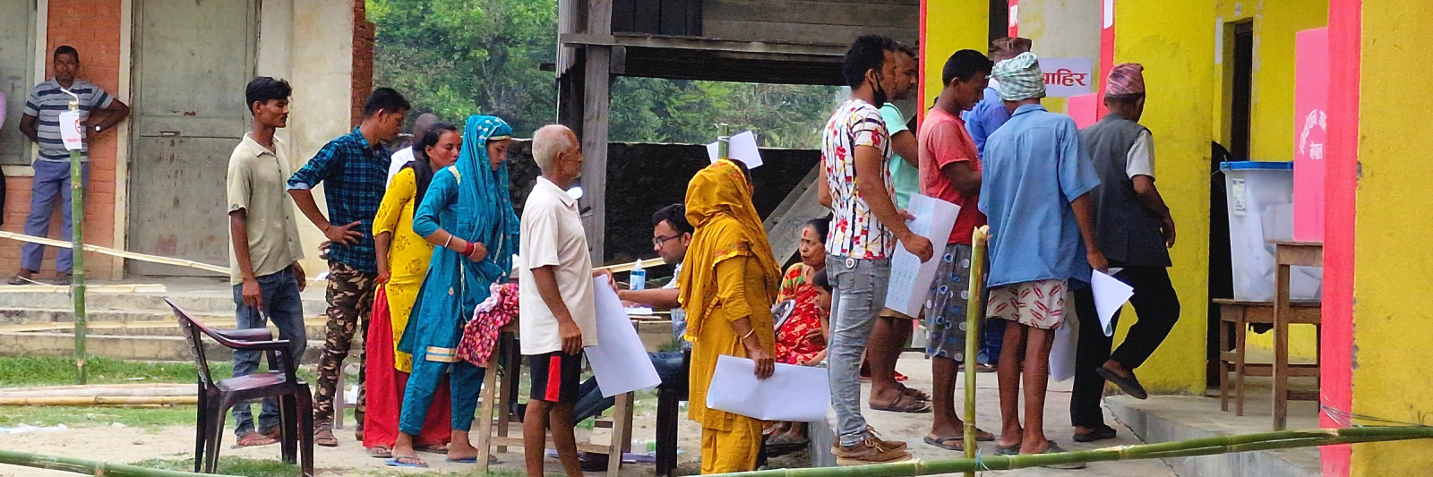 Voters waiting their turn in line to mark the ballot after receiving ballot paper.