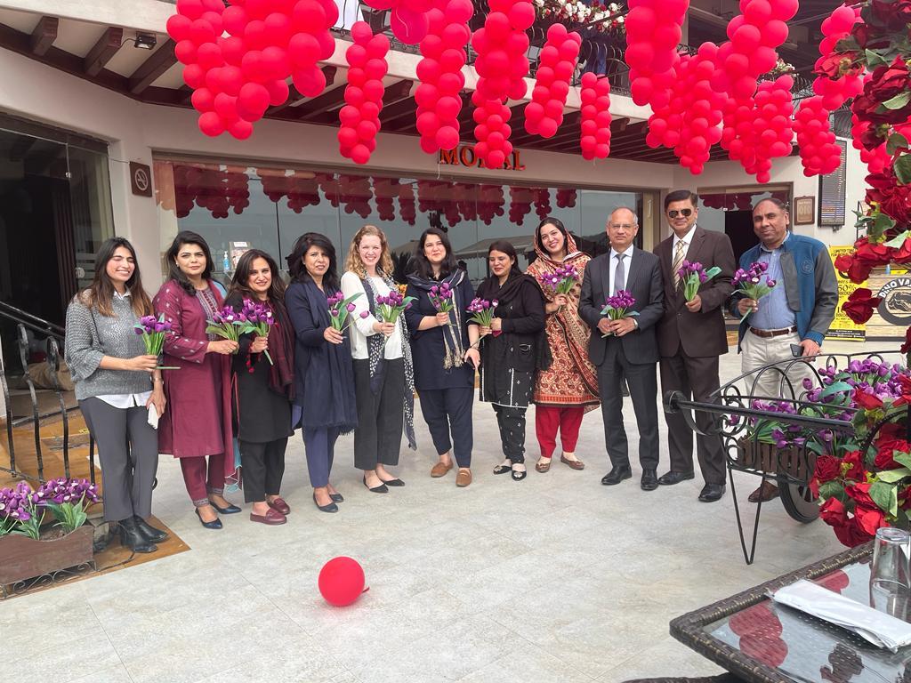 IFES Pakistan stands together under flowering tree for IWD 2023