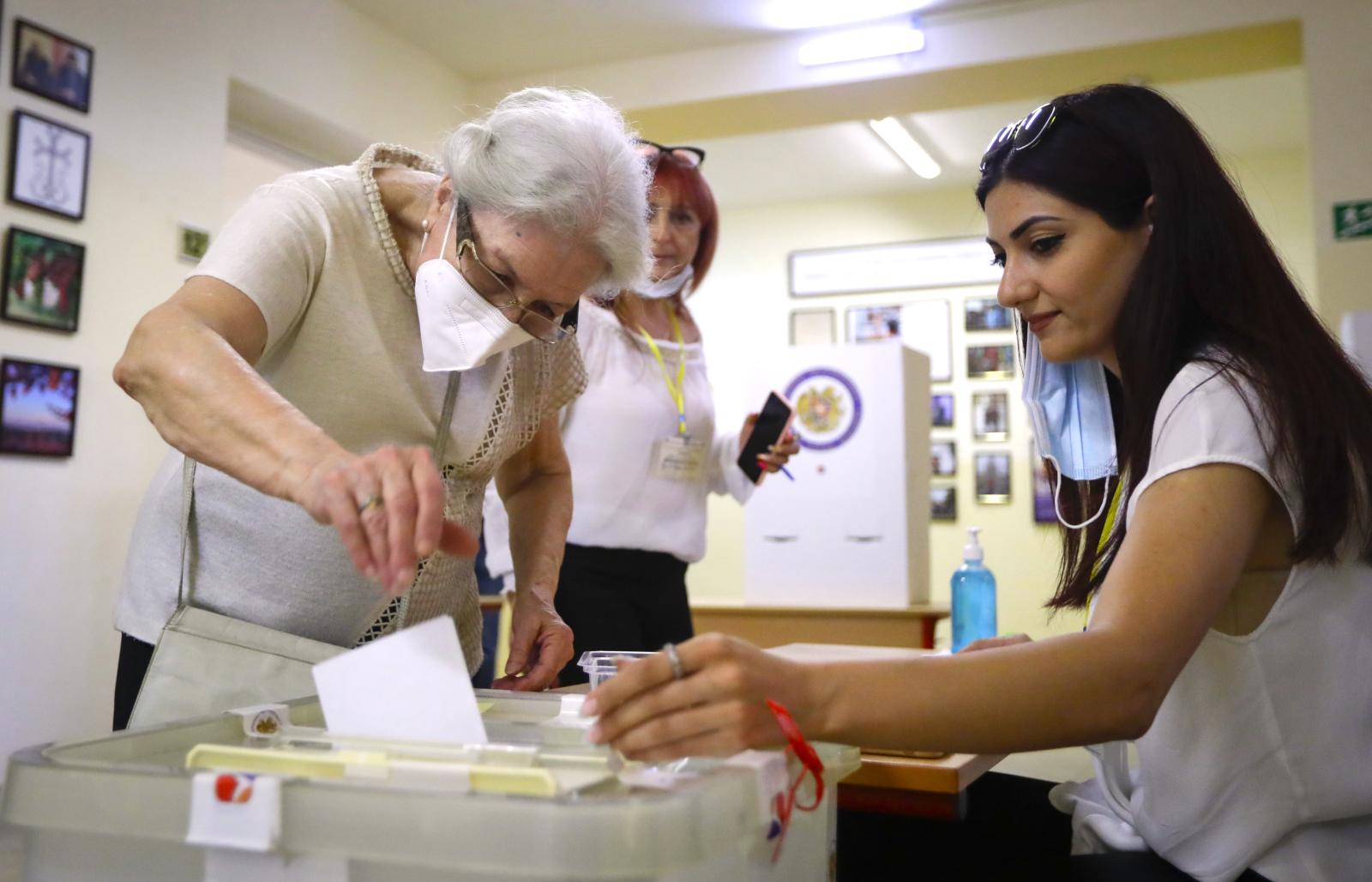 An Armenian woman casts her ballot paper at a polling station during a parliamentary election in Yerevan, Armenia, Sunday, June 20, 2021.