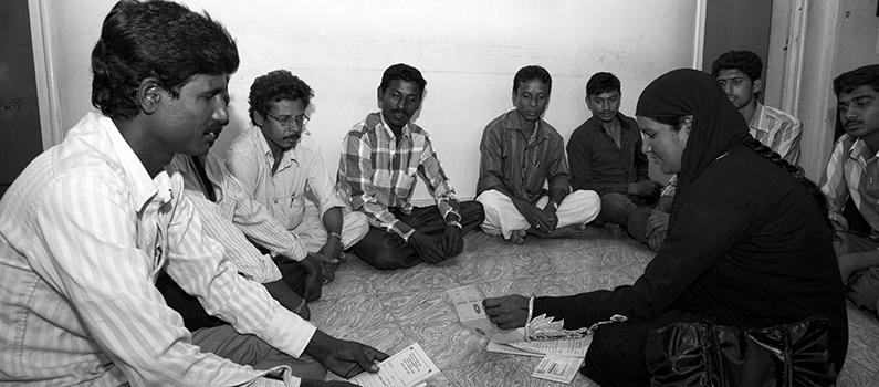 Men from the MWI sit in a circle.
