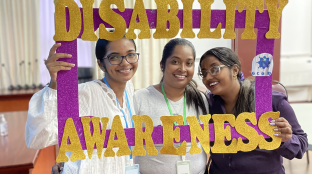 Youth with the conference's selfie frame promoting disability awareness