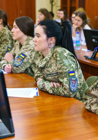 Ukrainian students seated in class in military uniforms