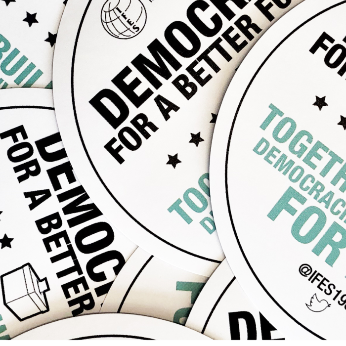 mission_and_vision_stickers_brightened.png 'Democracy for a better future buttons' laying on top of each other.