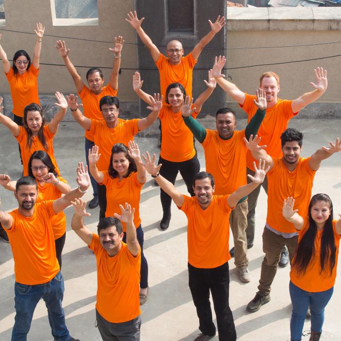 IFES Nepal staff  stand in orange against violence against women.