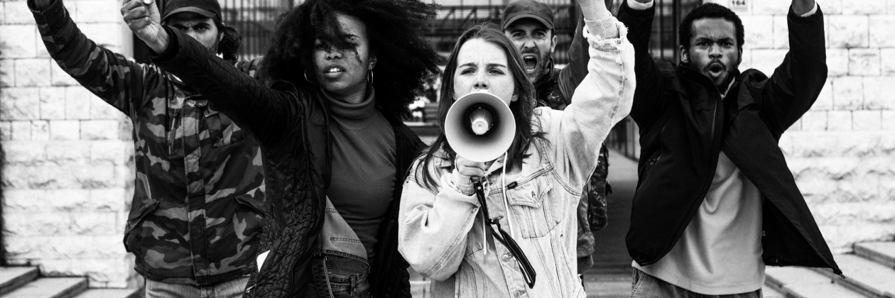 Mixed gender, multi racial group standing in protest.