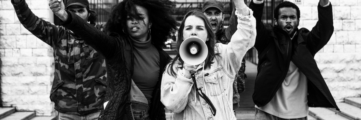 Mixed gender, multi racial group standing in protest. 