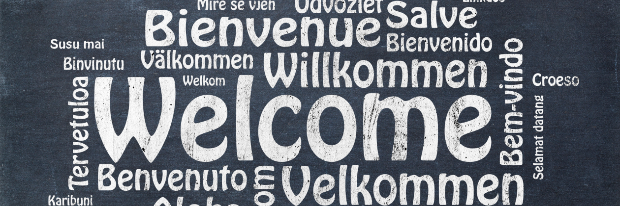 welcome in white text in many languages.
