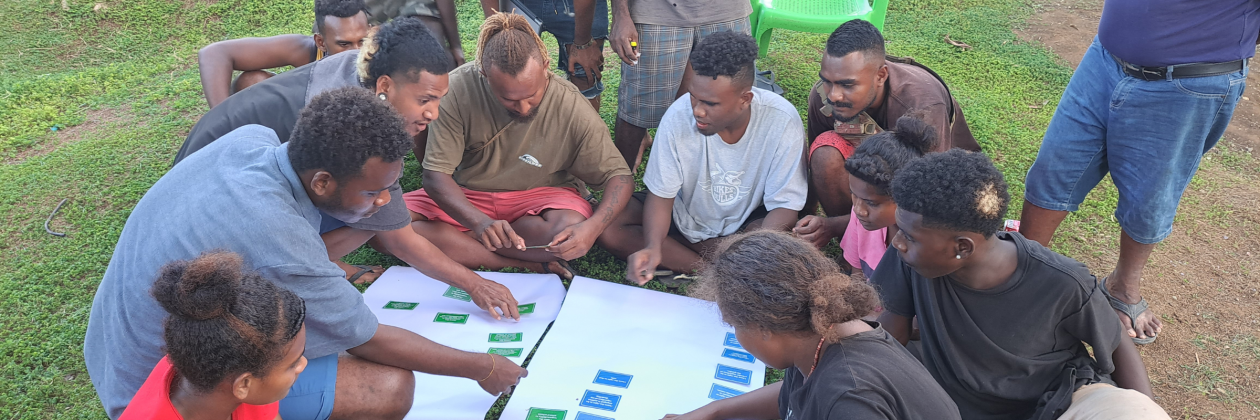 A group of young people sit together playing the Rights and Responsibilities game together.