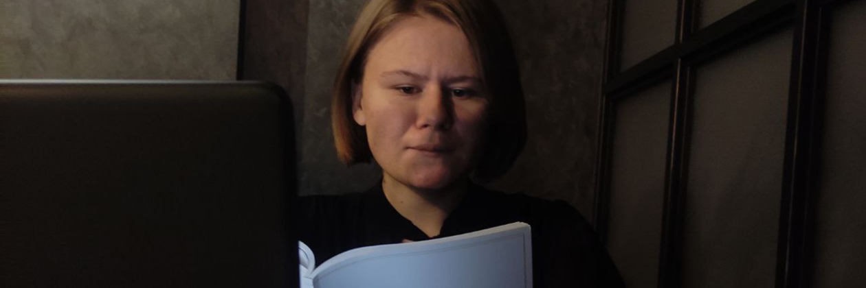 Anastasiia’s in a dark room reading.