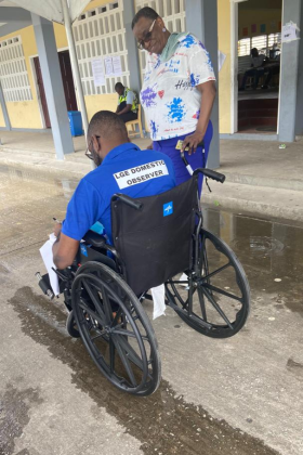 Election observer using a wheelchair chatting with a colleague