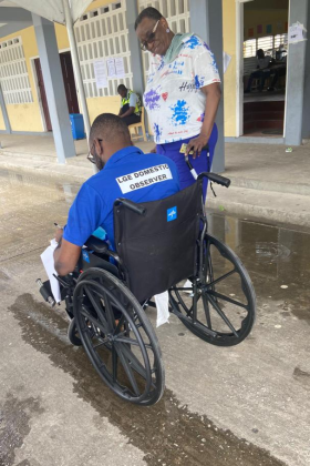 Election observer using a wheelchair chatting with a colleague 