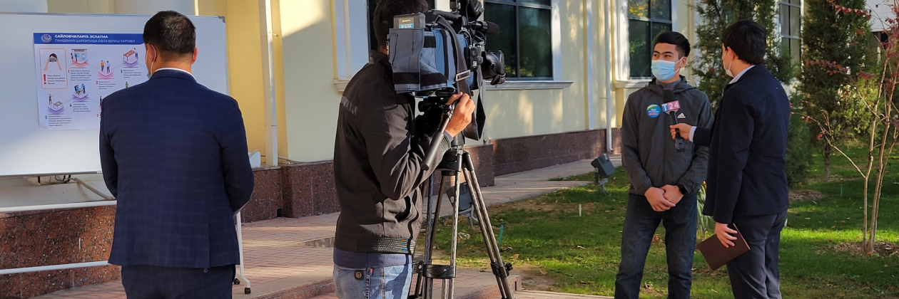 person operating camera with reporter in Uzbekistan.