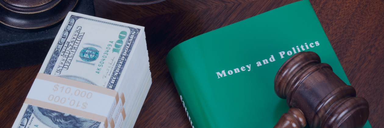 Book money and politics with gavel on top next to a stack of money on a desk. photo credit ericsphotography via canva pro