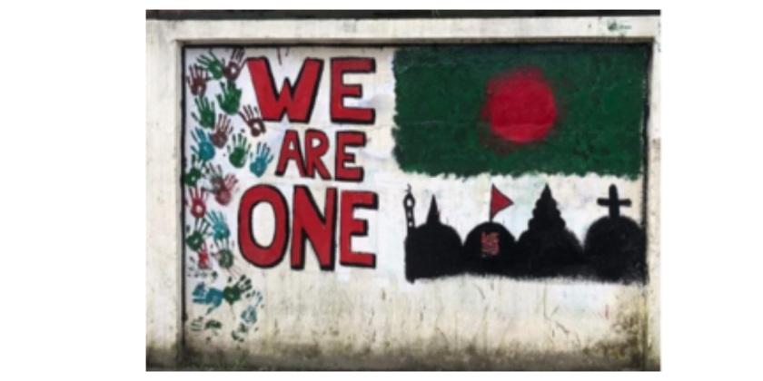 Mural with the phrase 'WE ARE ONE' painted in large letters, surrounded by handprints in various colors. Below the text, a silhouette skyline featuring a mosque, a temple, and a church, set against a red circle backdrop, symbolizing unity and diversity.