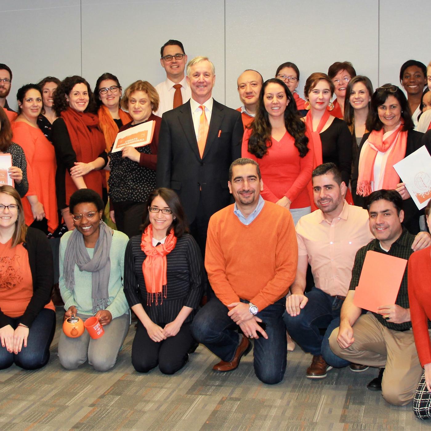 IFES HQ staff group photo in orange against violence against women. 