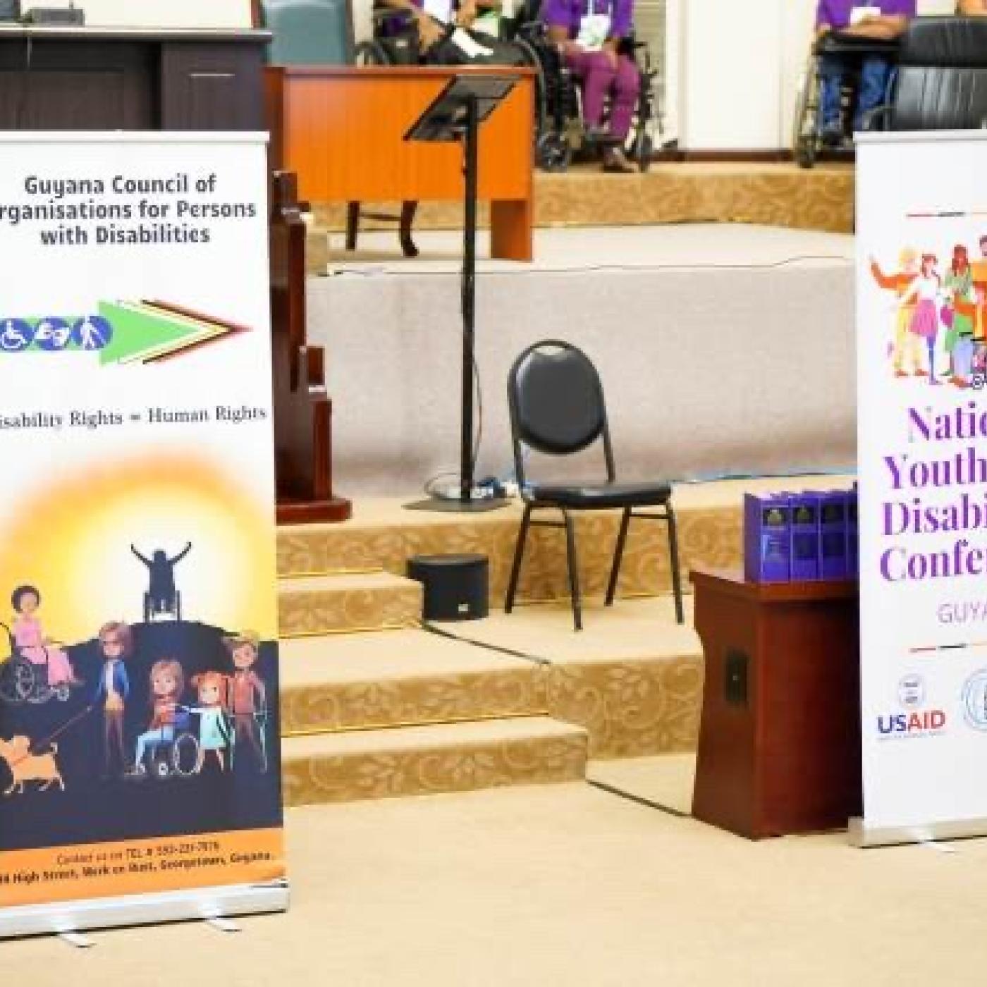 Photo of posters in front of chairs and desks at conference.