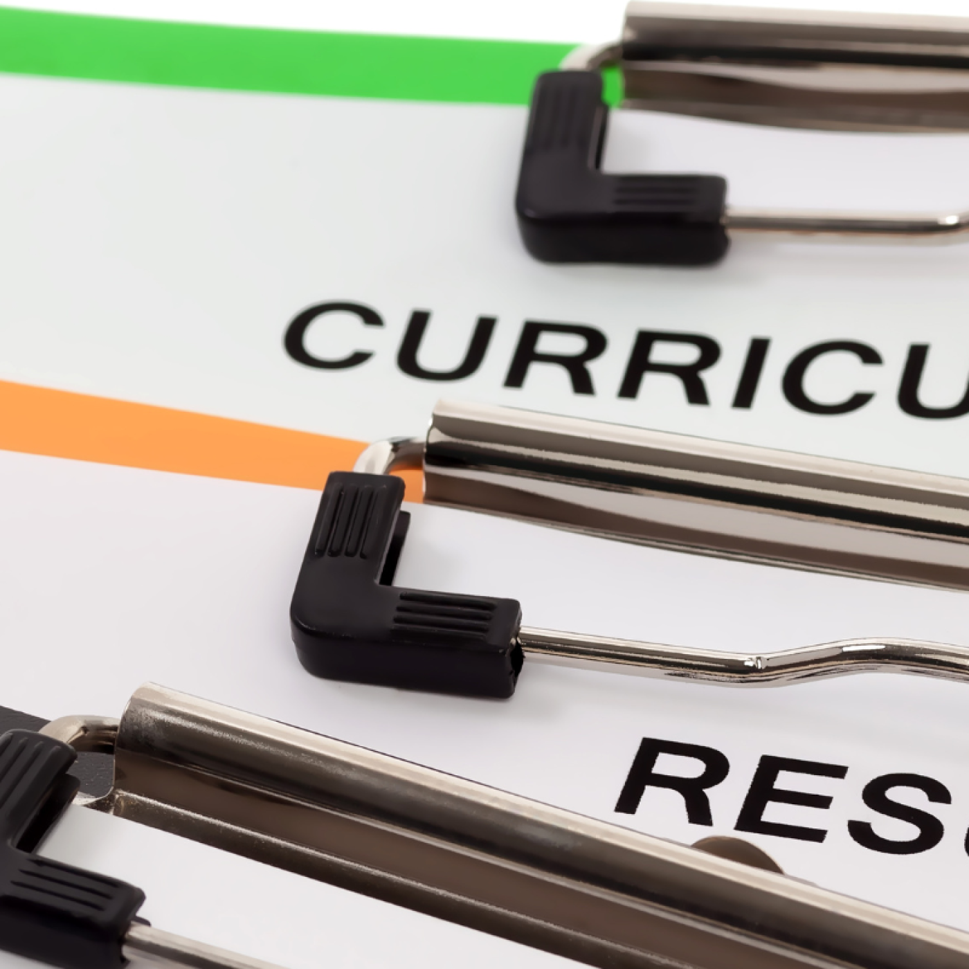 Three clipboards on top of each other read Curriculum Vitae, Resume and Job Application
