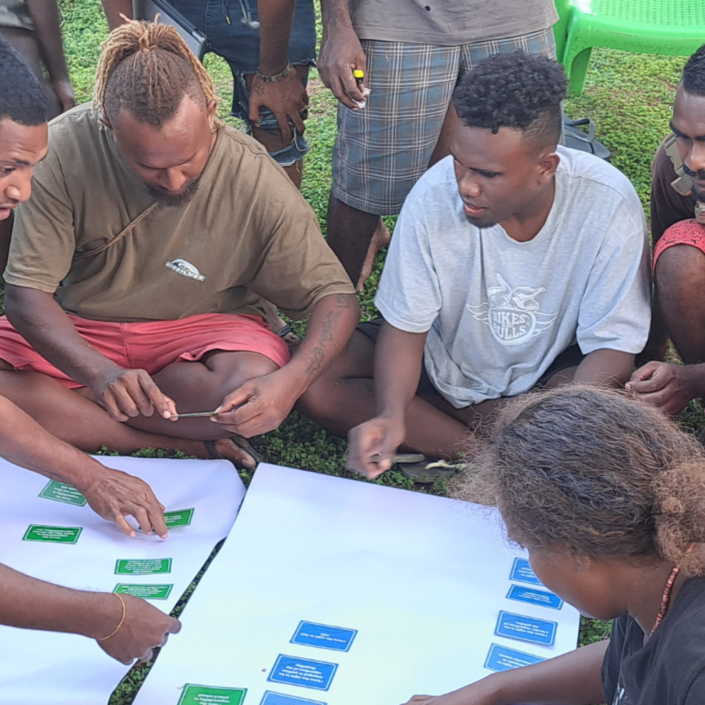 A group of young people sit together playing the Rights and Responsibilities game together.